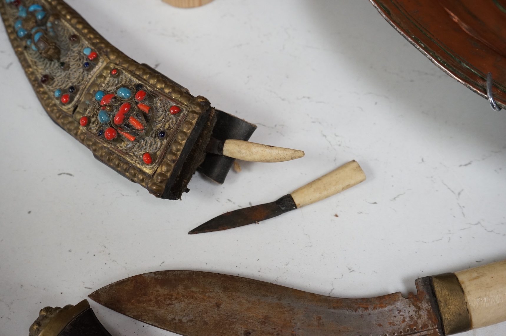 An Indian Tulwar sword, in scabbard and two small kukri, largest 93cm long.